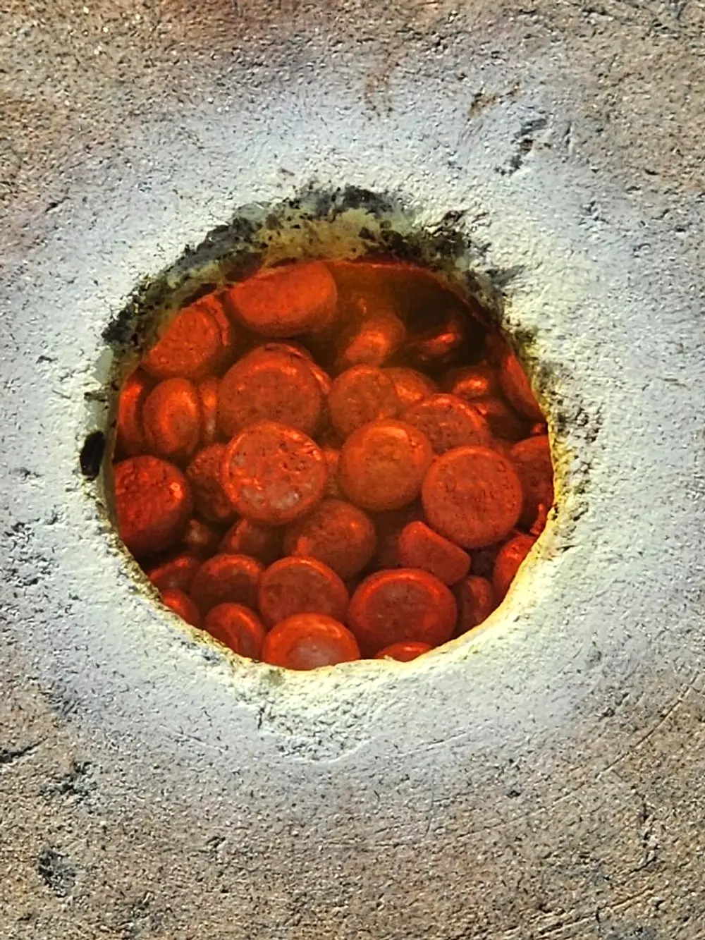 Heated gold samples during cupellation in a local assay furnace