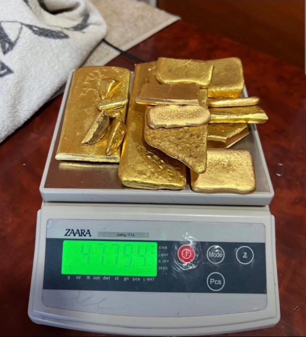 Gold bars arranged on a digital scale for weight verification